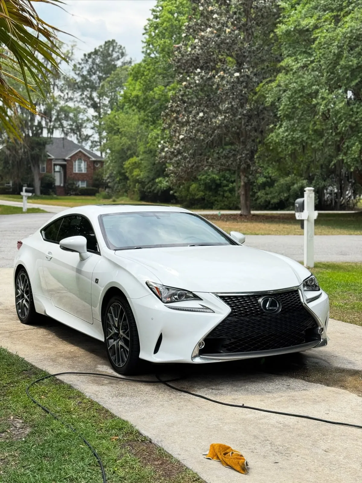 White Lexus RC coupe in a driveway after a wash