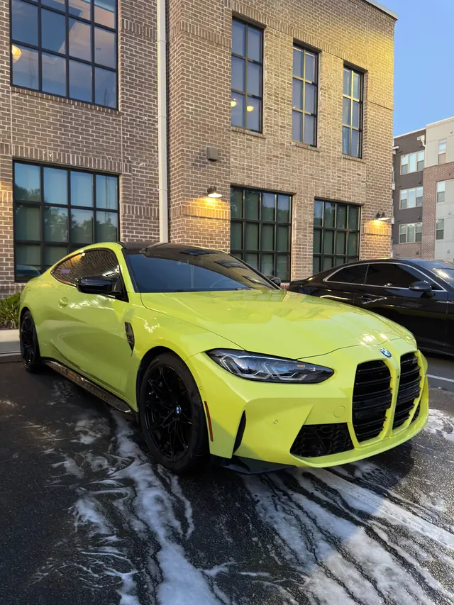 Lime green BMW M4 with foam running off after a wash