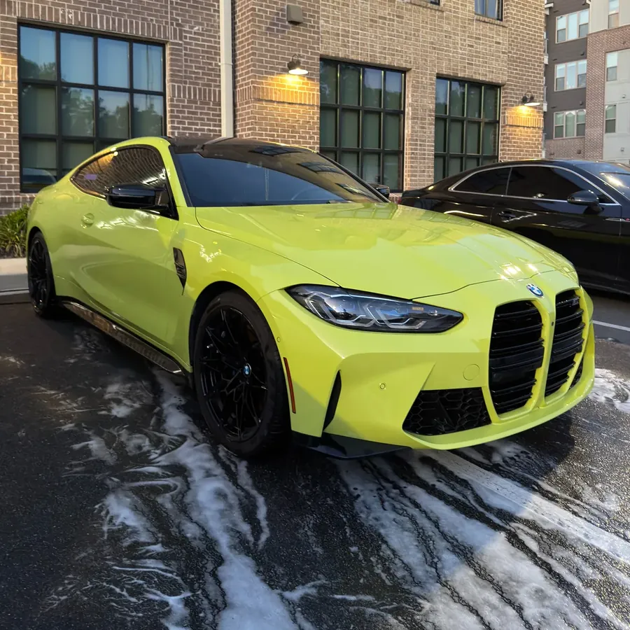 Lime green BMW M4 with foam running off after a wash